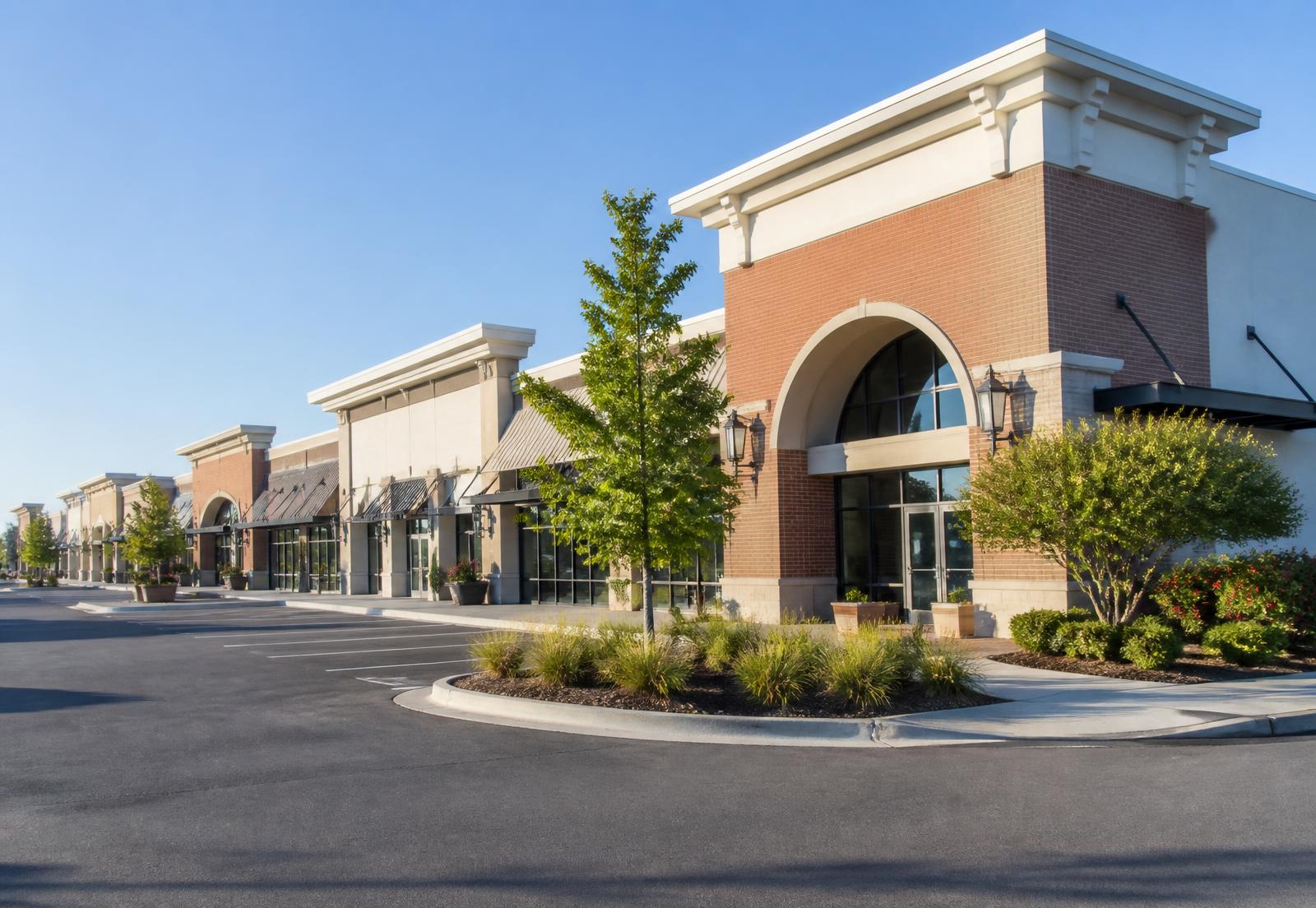Open-air neighborhood strip center with storefronts and shop-space vacancy